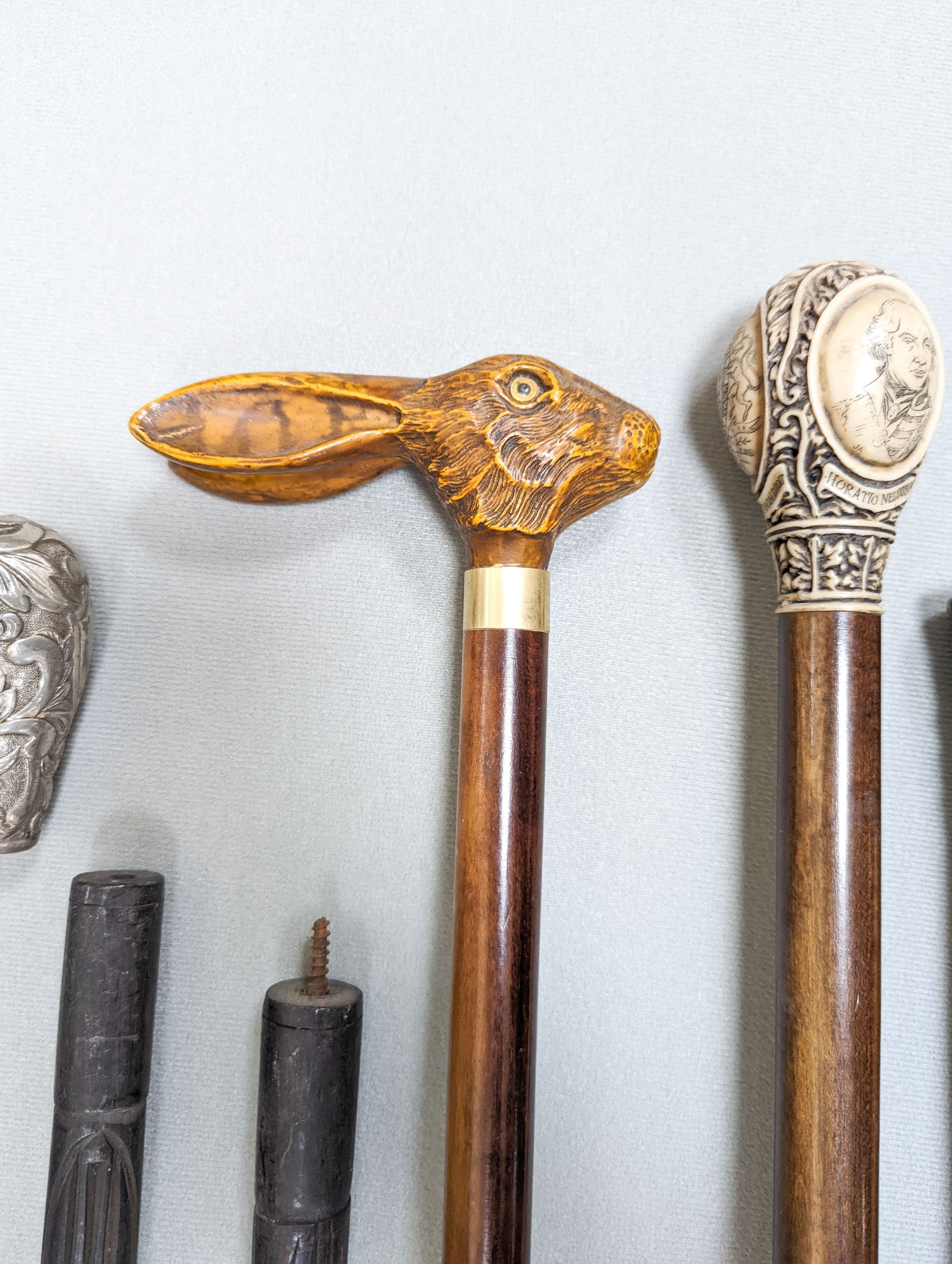 A gold mounted ivory handled walking cane carved with a coiled snake, a silver mounted Mallacca cane, an ivory handled ebonised stick and six others. (9)